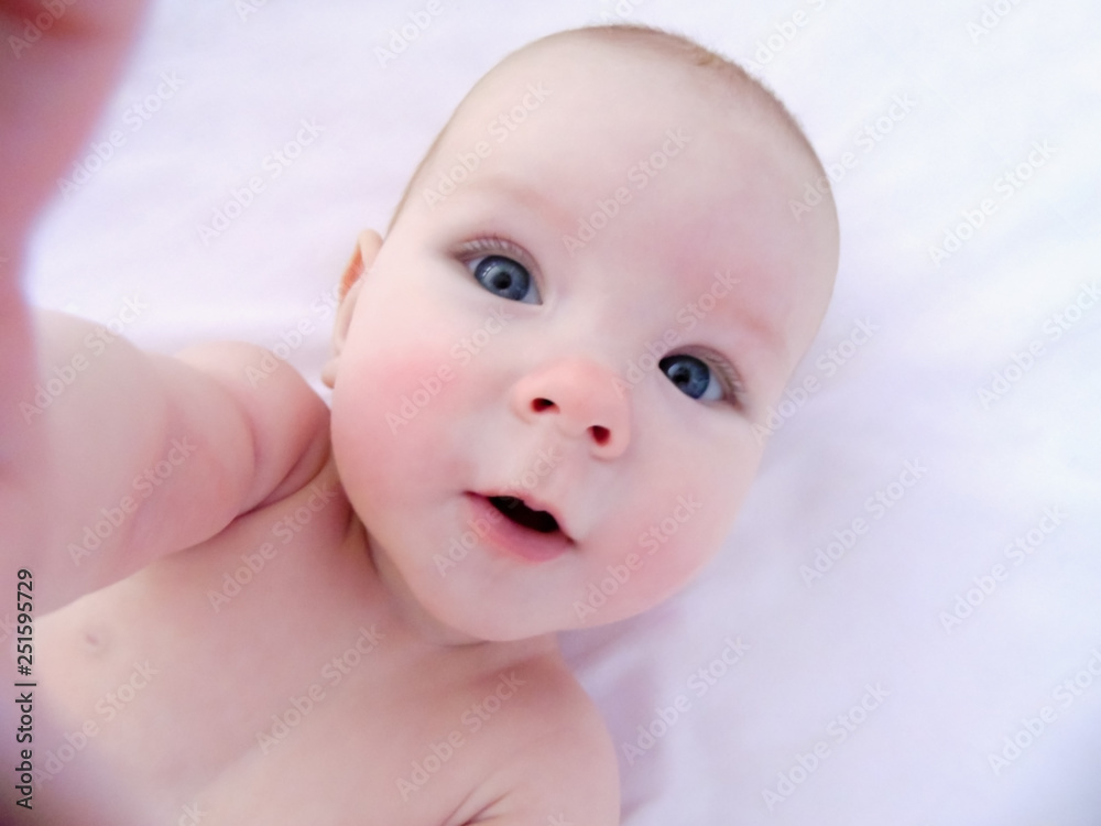 Little cheerful baby girl baby takes sun and air baths, skin dipping. The baby has redness on the cheeks, similar to frostbite. Little cheerful baby girl baby takes sun and air baths, skin dipping. The baby has redness on the cheeks, similar to frostbite.