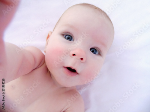 Obraz na plátně Little cheerful baby girl baby takes sun and air baths, skin dipping