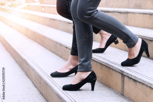 Close up two shoes legs of businesswoman walking stepping down stair in modern city hurry time, People walk rush hour to work in the streets. Business concept.