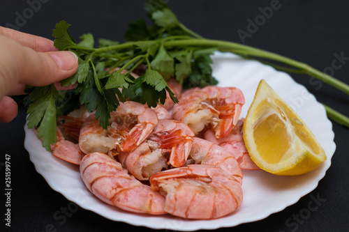 Shrimps, lemon and greens on a white plate