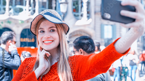 Happy young woman making selfie while visiting city