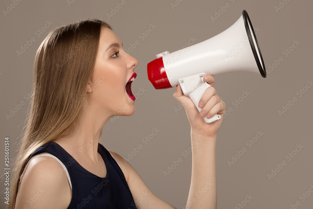 woman scream in a megaphone. Gray background woman scream in a megaphone. Gray background