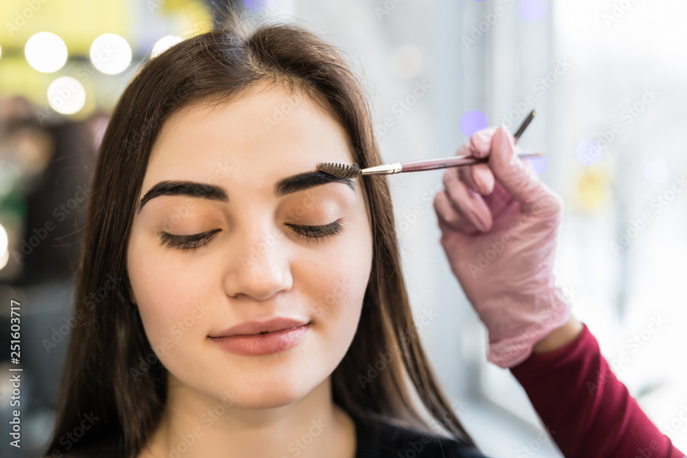 Make-Up. Beautician Hands Doing Eyebrow Tattoo On Woman Face.Permanent Brow Makeup In Beauty Salon. Closeup Of Specialist Doing Eyebrow For Female. Make-Up. Beautician Hands Doing Eyebrow Tattoo On Woman Face.Permanent Brow Makeup In Beauty Salon. Closeup Of Specialist Doing Eyebrow For Female.