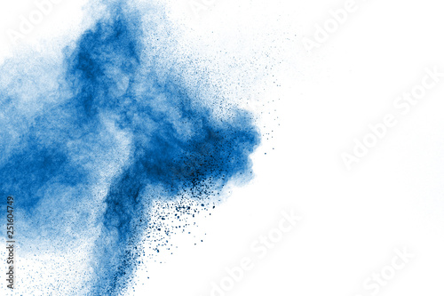 Abstract blue dust explosion on white background. Freeze motion of blue particles splashing. Painted Holi in festival.