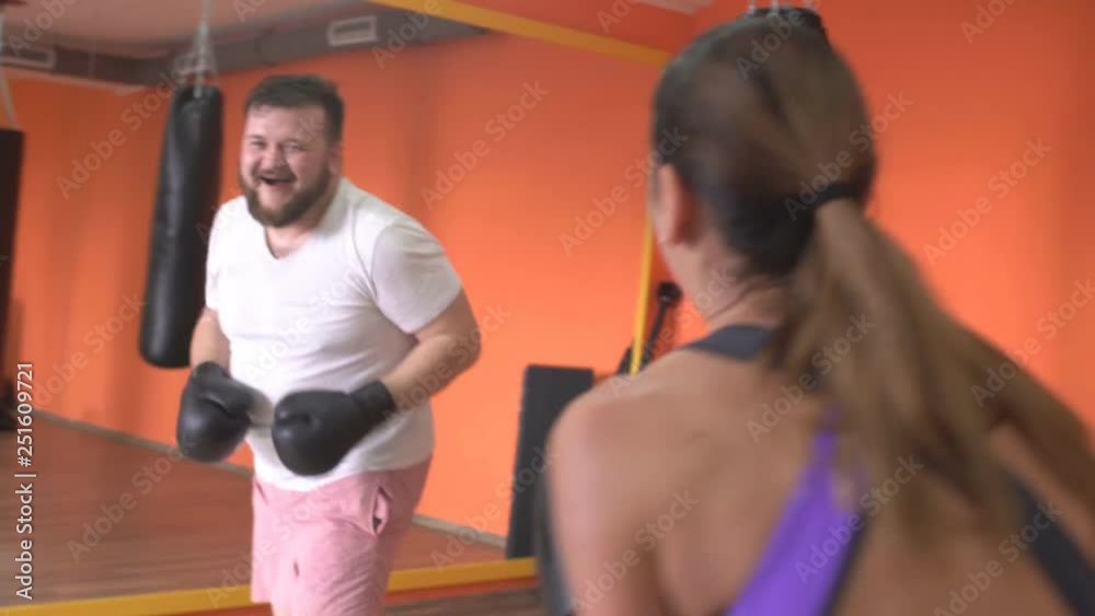 Man and woman fighting in boxing gloves in the gym, sparring, sportsman Man and woman fighting in boxing gloves in the gym, sparring, sportsman