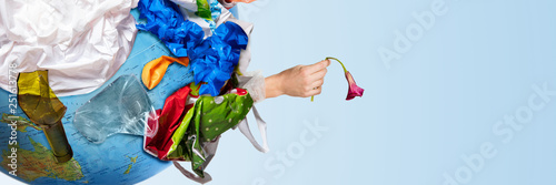 An earth globe covered with trash and male hand with a withering flower over white background, the concept of ecology problem and World Environment Day. Photo with message for social advertising