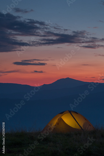 A yellow tent in mountains