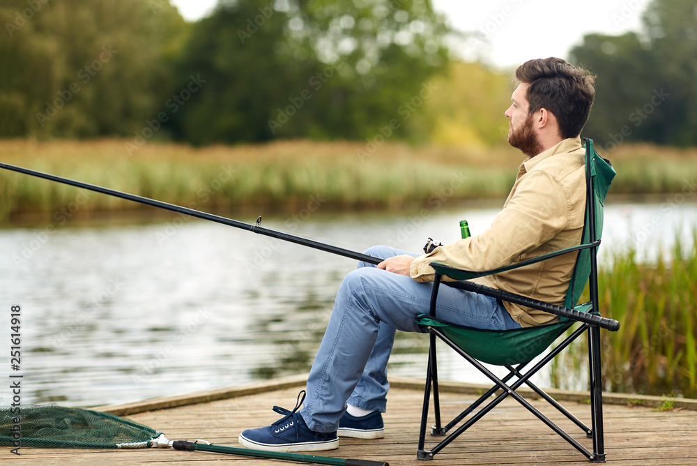 leisure and people concept - bearded fisherman with fishing rod at lake leisure and people concept - bearded fisherman with fishing rod at lake