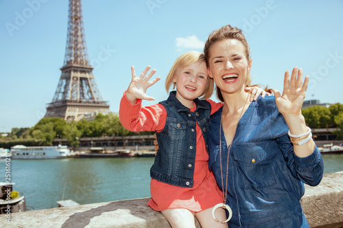 happy modern mother and daughter travellers handwaving photo