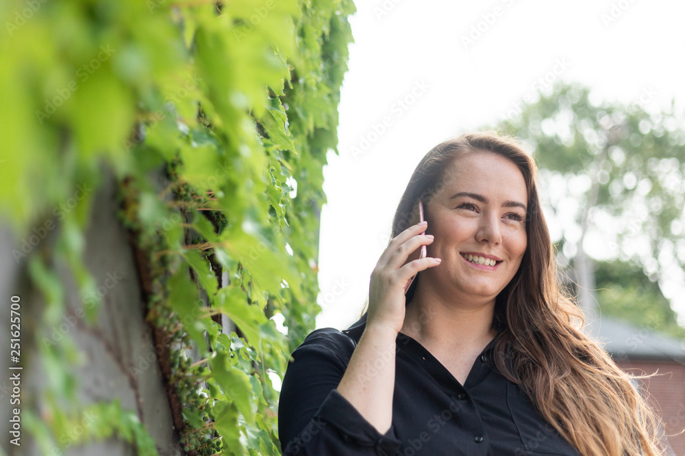 Smiling young woman using mobile phone outdoors Smiling young woman using mobile phone outdoors