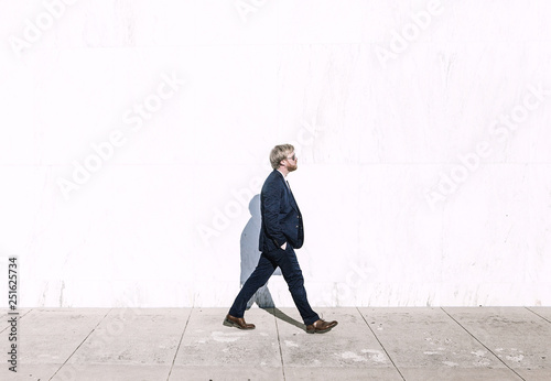 Side view of man walking on sidewalk photo