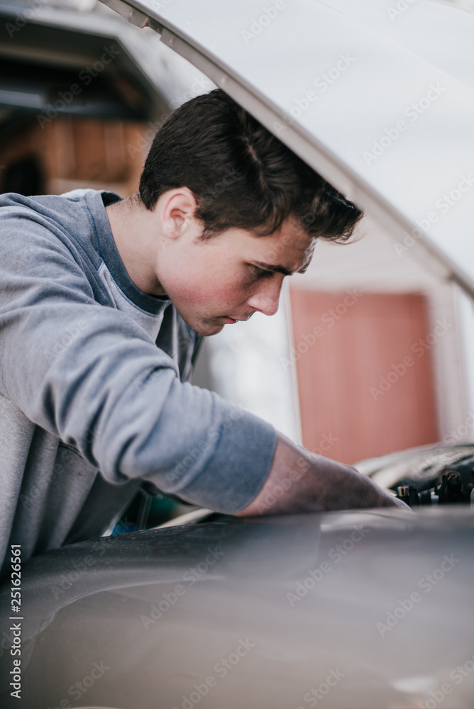 Young man repairing car bonnet outdoors Young man repairing car bonnet outdoors