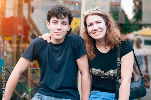 Happy mother hug her teenage son and rejoices because she is reconciled with her son with whom she had a complicated relationship