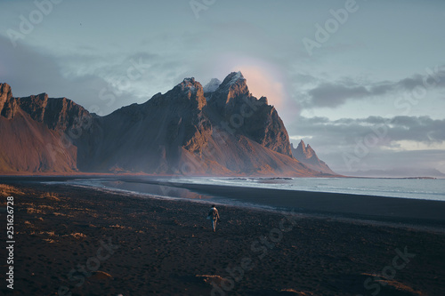 Rear view of man walking on beach during sunset