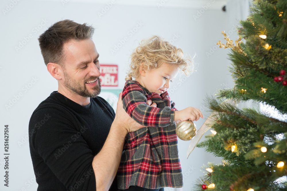 Father and daughter decorating Christmas tree at home Father and daughter decorating Christmas tree at home