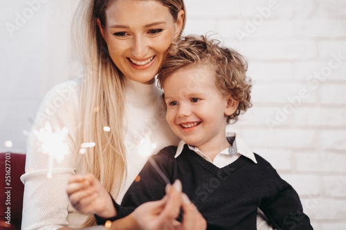 Smiling mother and son holding sparklers