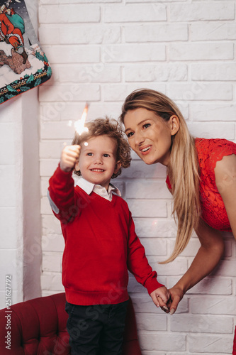 Mother and son with sparkler at home during Christmas