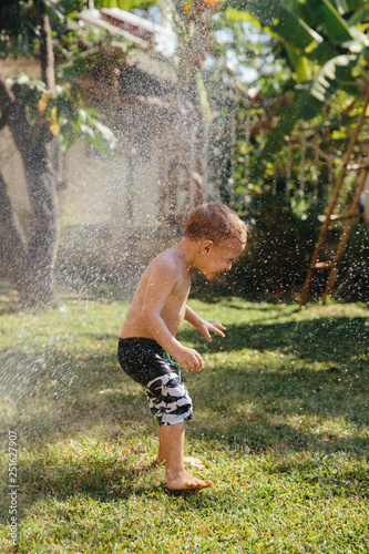 Shirtless boy playing in water outdoors