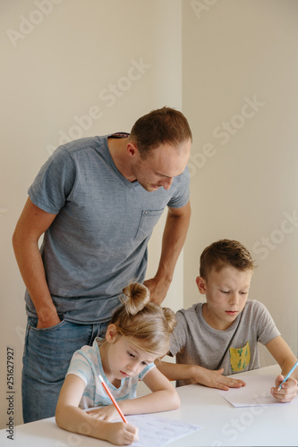 Father looking at his children while studying at home