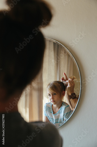 Mother tying up daughter's hair