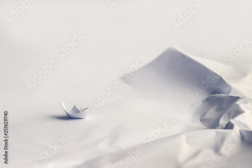 Origami concept. Boat at a rocky bay