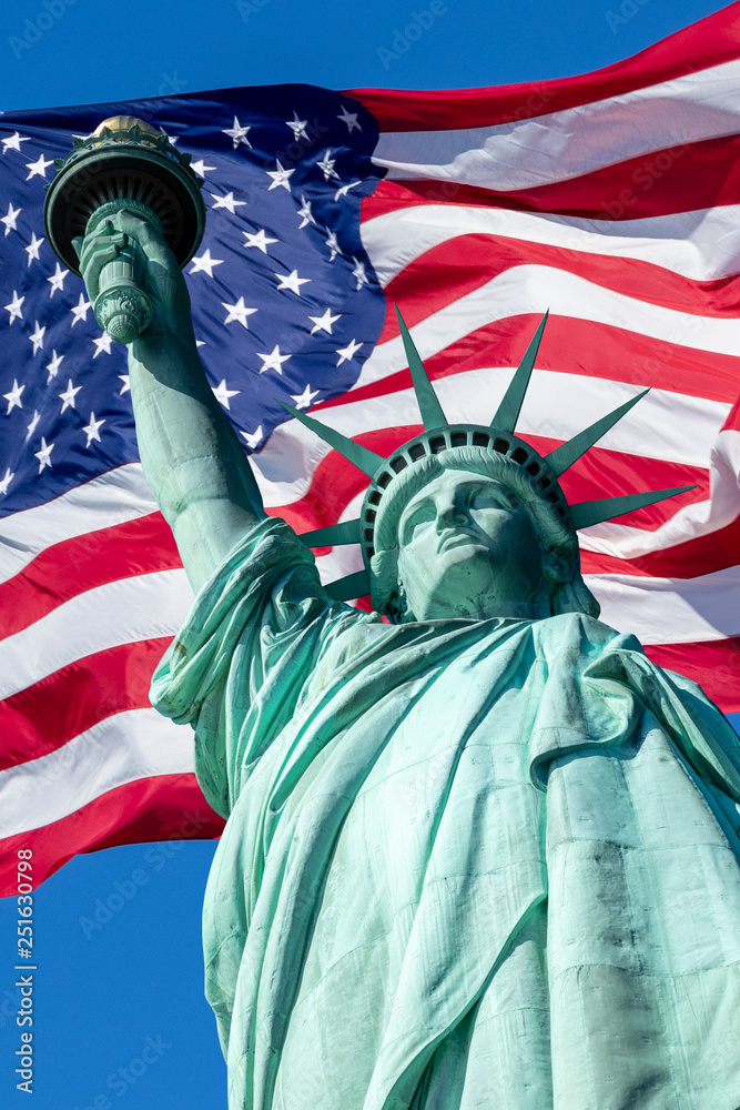 Obraz premium Freiheitsstatue mit amerikanischer Flagge im Hintergrund