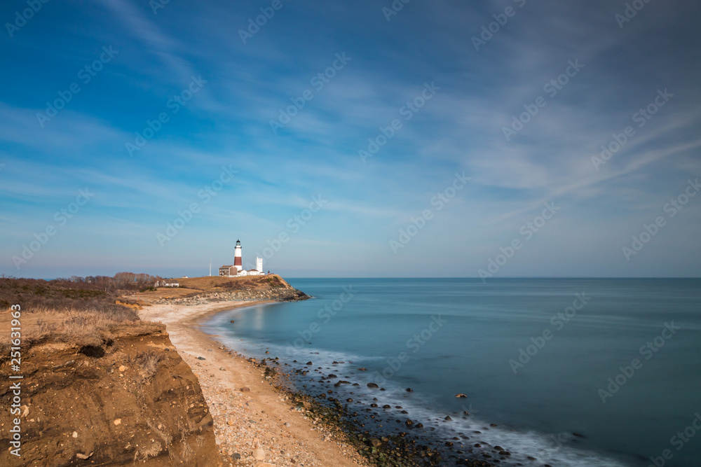 Rugged coastline leading to an old lighthouse protecting the island. Montauk Point, New York. 