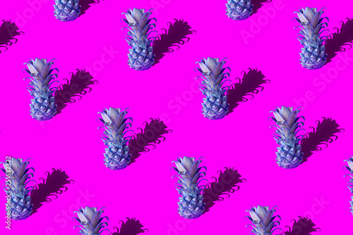 Neon pineapple fruits pattern on pink and blue background. Summer concept