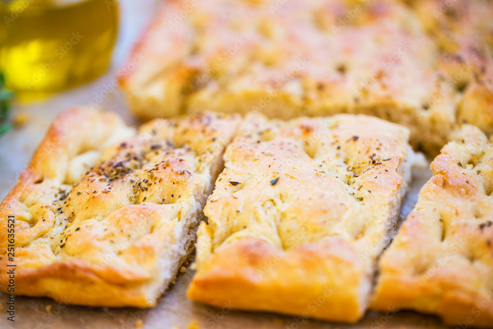Focaccia bread with oregano and olive oil.Fresh italian foccacia bread closeup with mediterranean ingredients Focaccia bread with oregano and olive oil.Fresh italian foccacia bread closeup with mediterranean ingredients