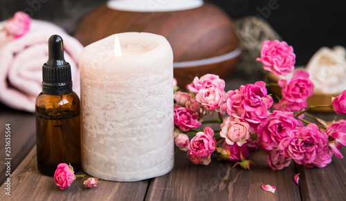 Spa still life with roses, candle and oil bottle.Wellness setting spa and aromatherapy