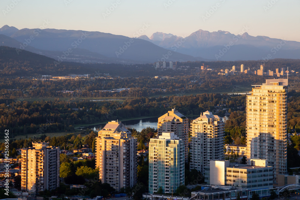 Obraz premium Widok z lotu ptaka na nowoczesne miasto podczas tętniącego życiem zachodu słońca. Zrobiono w Metrotown, Burnaby, Vancouver, BC, Kanada.