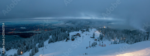 Panoramic view of Grouse Mountain Ski Resort during a cloudy winter sunset. Taken in North Vancouver, British Columbia, Canada.