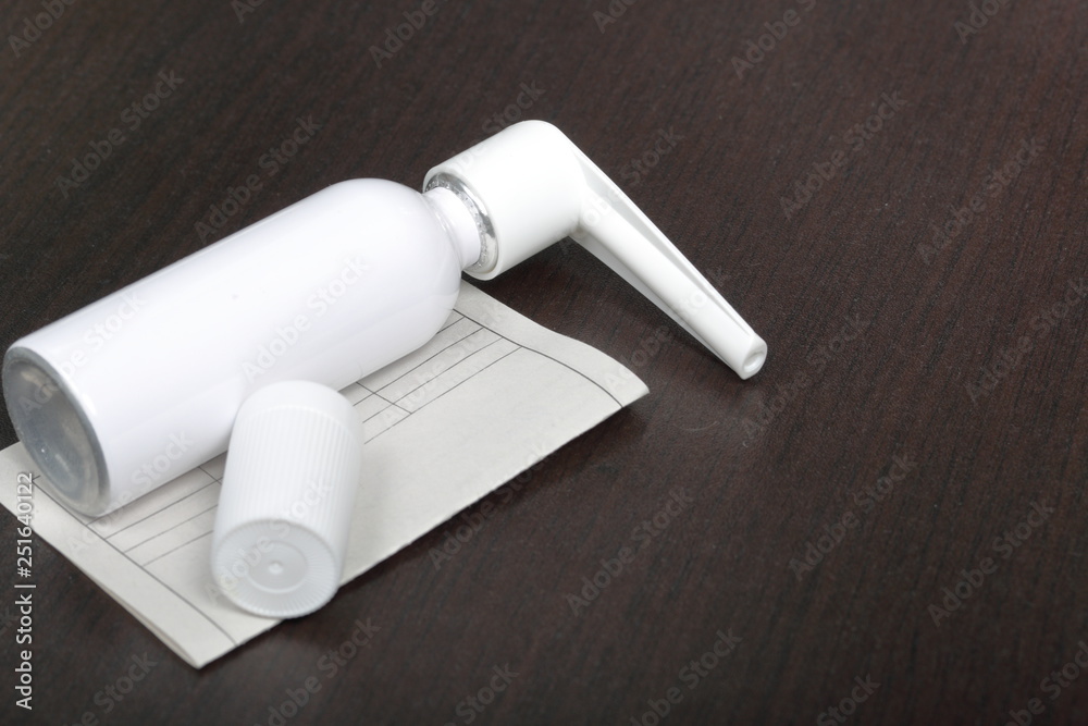 Inhaler for the treatment of respiratory organs. Spray can and cap white. Next recipe to buy. On a dark surface.