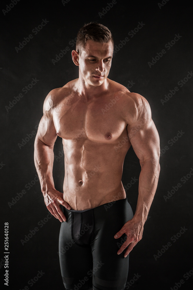 Athletic shirtless young male fitness model posing