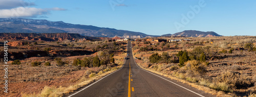 Scenic road in the desert during a vibrant sunny sunrise. Taken on Route 24 near Torrey, Utah, United States of America. photo