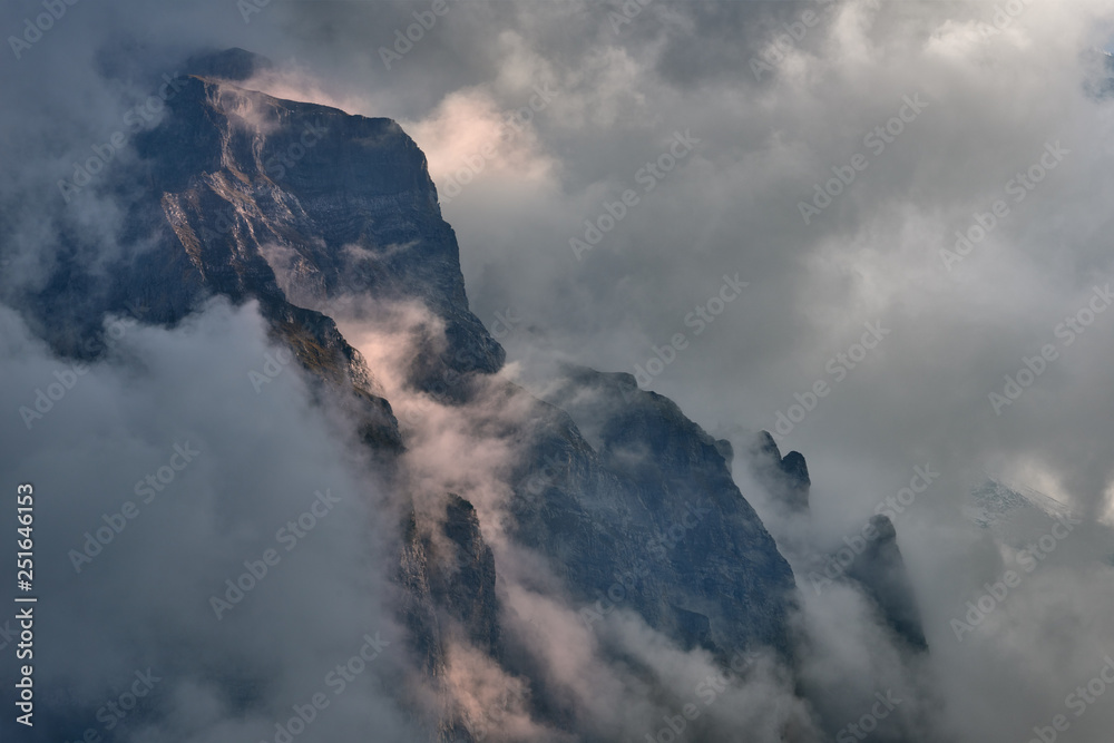Dramatic scenery of the mountains covered by the clouds at sunset. Lauterbrunnen valley in Switzerland.