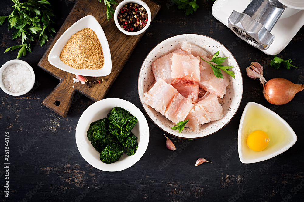 Ingredients for homemade Fish Cake cod, spinach, egg and breadcrumbs. Raw cutlets from minced cod. Top view. Ingredients for homemade Fish Cake cod, spinach, egg and breadcrumbs. Raw cutlets from minced cod. Top view.