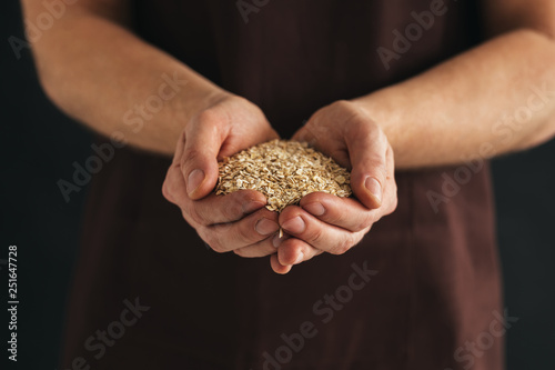 A man with a handful of oat flakes in his hands