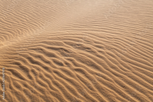 Amazing abstract background image of ripples and waves in the sand at sunrise
