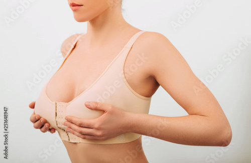 Woman wearing at special slimming bra, after breast augmentation