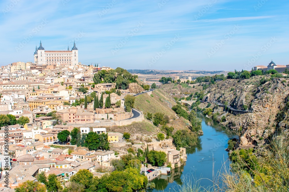 A panoramic view of the old city of Toledo, with it’s castle inside the city walls, surrounded by a ravine and river that serves as a moat.
