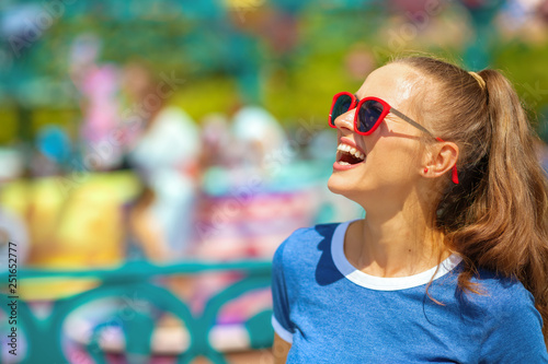smiling traveller woman in amusement park having fun time