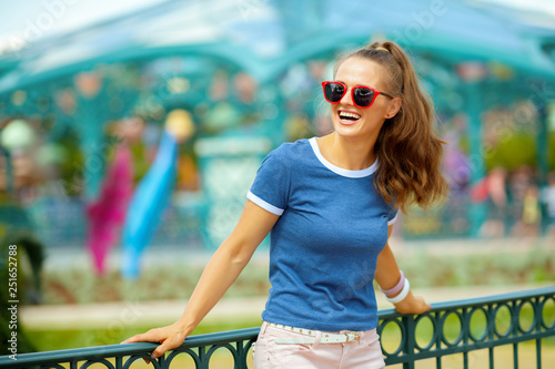 smiling trendy woman in theme park looking into distance © Alliance
