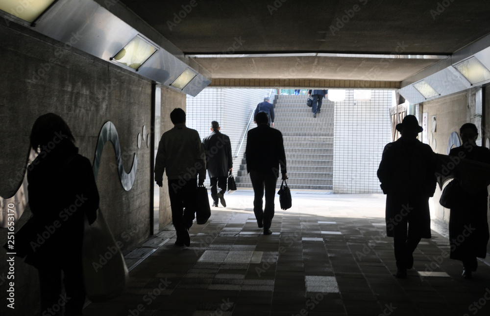 people silhouette walking in a tunnel