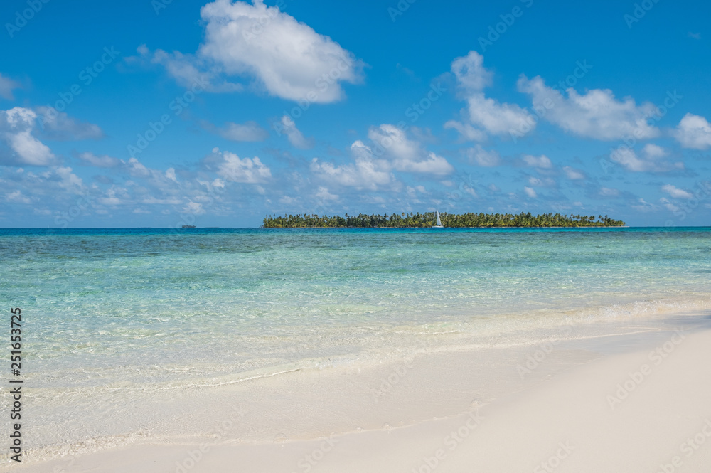 white sand beach with tropical palm tree island