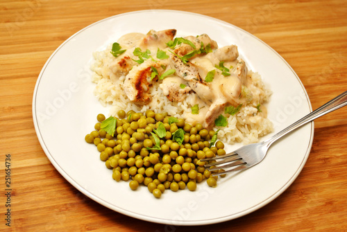 Pork with Cream Sauce Over White Rice & a Side Dish of Peas