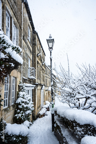 A view along the houses of Tory, Bradford on Avon, during snowy weather with a old fashioned styled street lamp