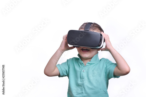 Amazed teen boy wearing virtual reality goggles watching movies or playing video games  isolated on white. Surprised teenager looking in VR glasses. Emotional portrait of child experiencing 3D gadget