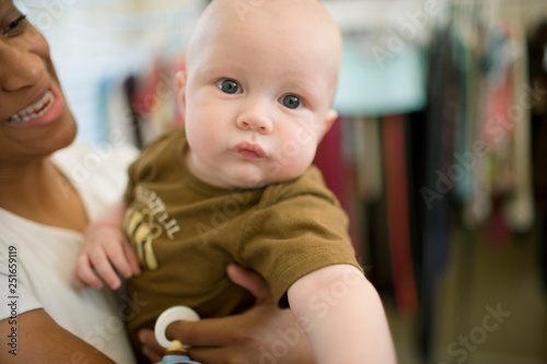 Portrait of a baby being held by a mid-adult woman.