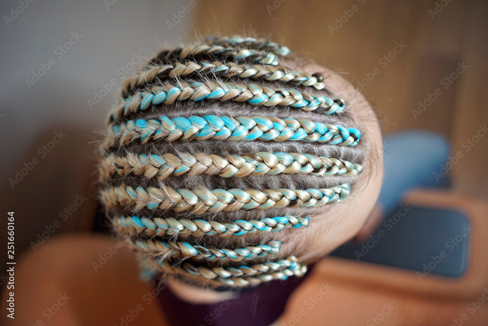 cornrows women A woman with a haircut on a white background, tight braids braided into a tail, artificial material woven into her hair